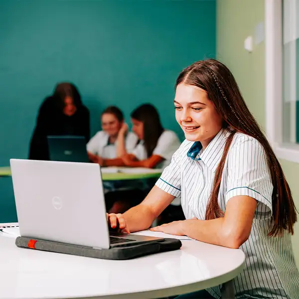 Student using laptop in classroom