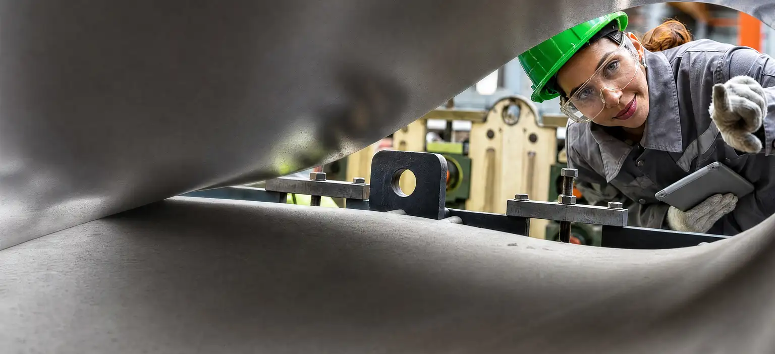 Factory worker inspecting machinery in industrial setting
