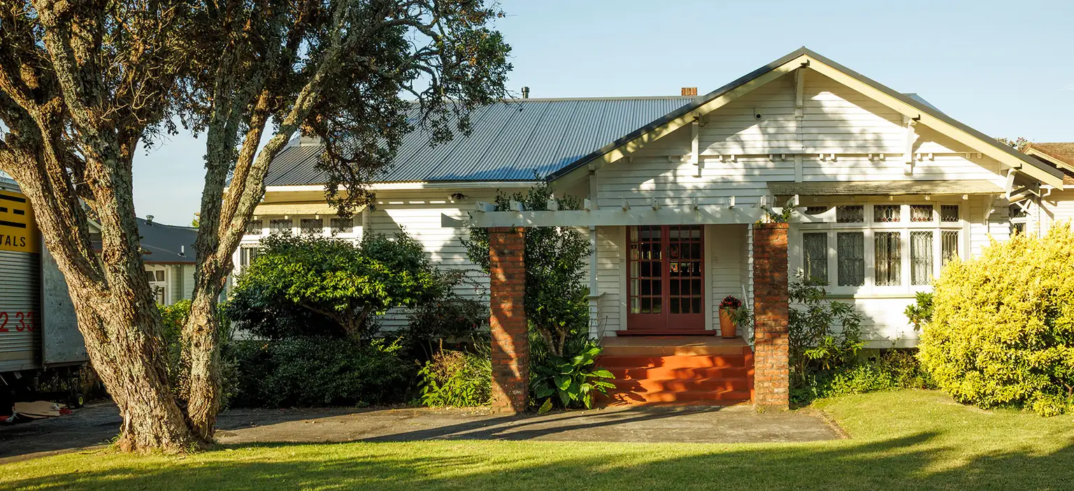 House in sunny garden setting with trees wide shot
