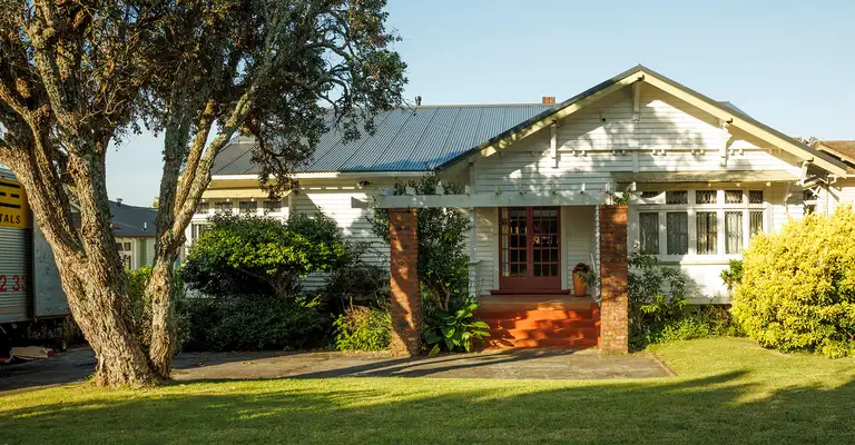 House in sunny garden setting with trees wide shot