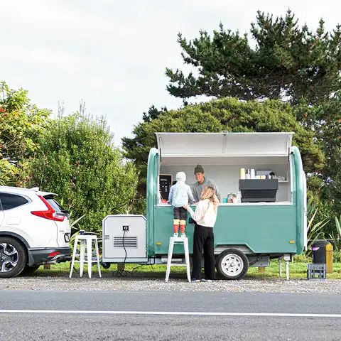 Mother and child ordering from coffee cart on side of the road