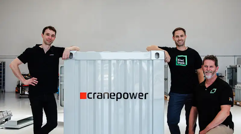 3 men around a grey Cranepower power pack