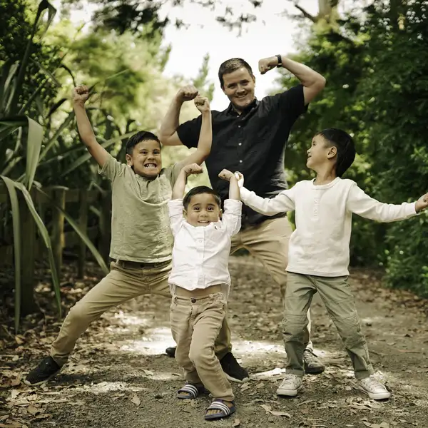 Adult and children posing on outdoor path with greenery