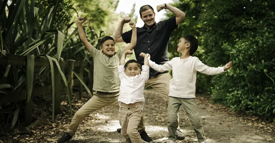Adult and children posing on outdoor path with greenery