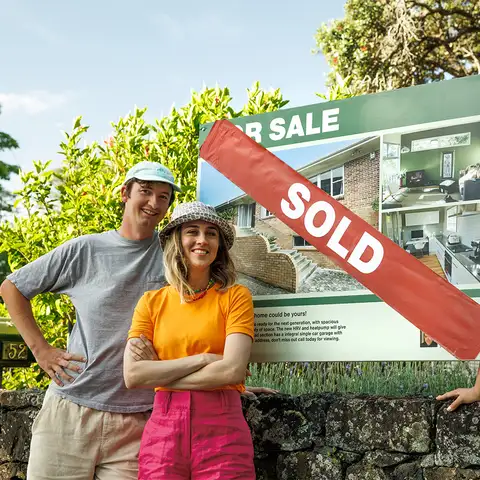 Friends outside with sold sign