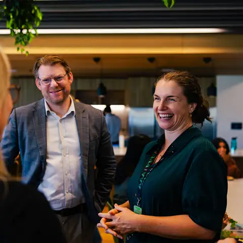 Two people talking in office kitchen