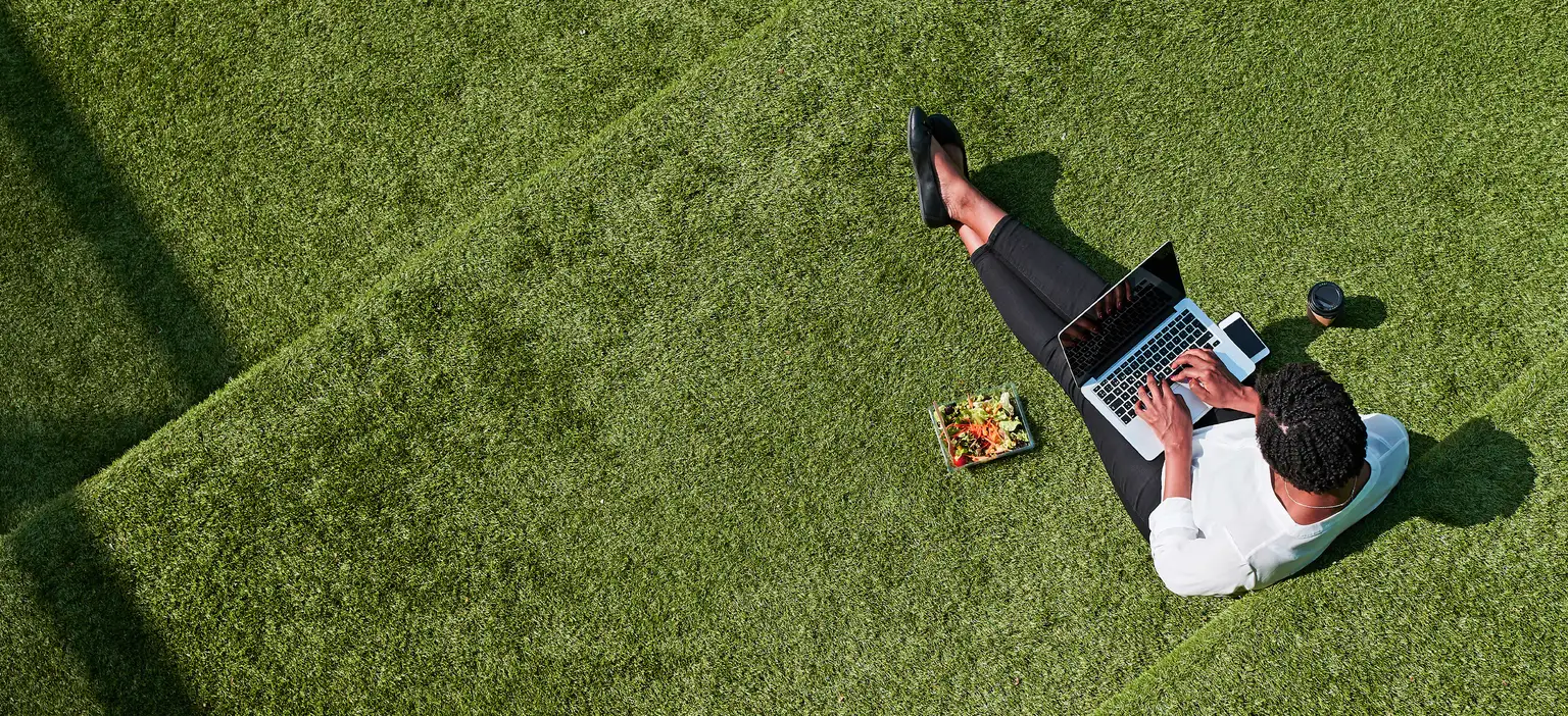 Lady sitting on grass on laptop