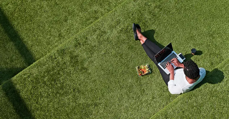 Lady sitting on grass on laptop