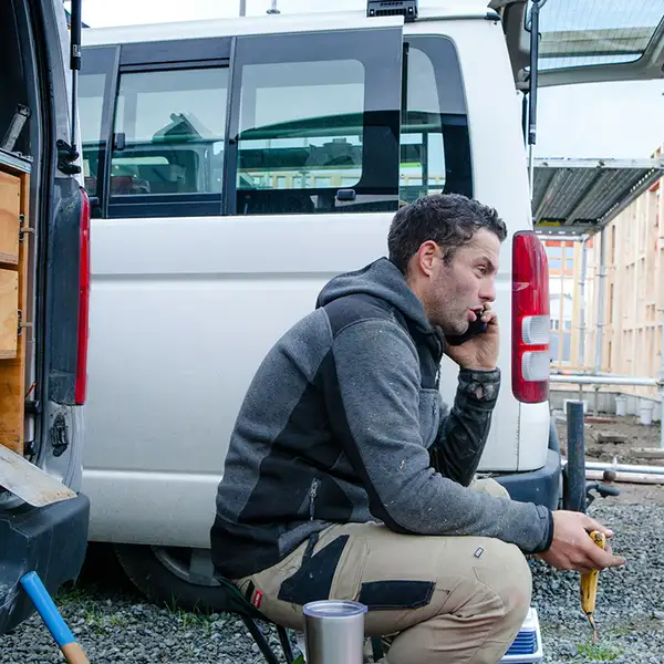 Builder using phone construction site van