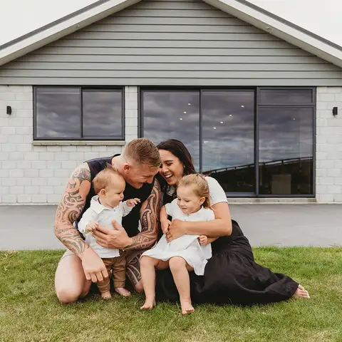 Mum dad 2 kids infront of house