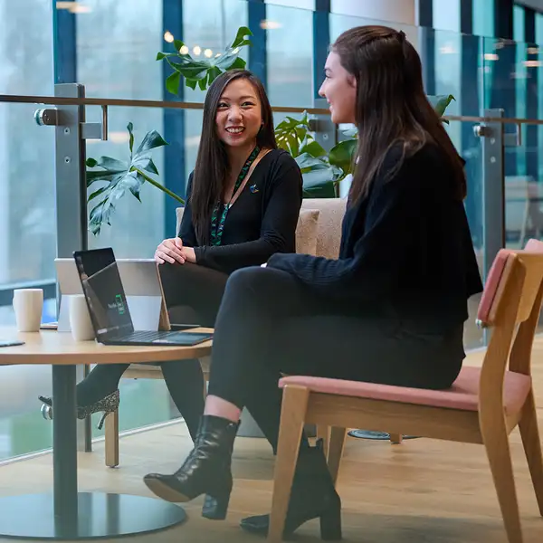 Two Kiwibank staff talking in the office