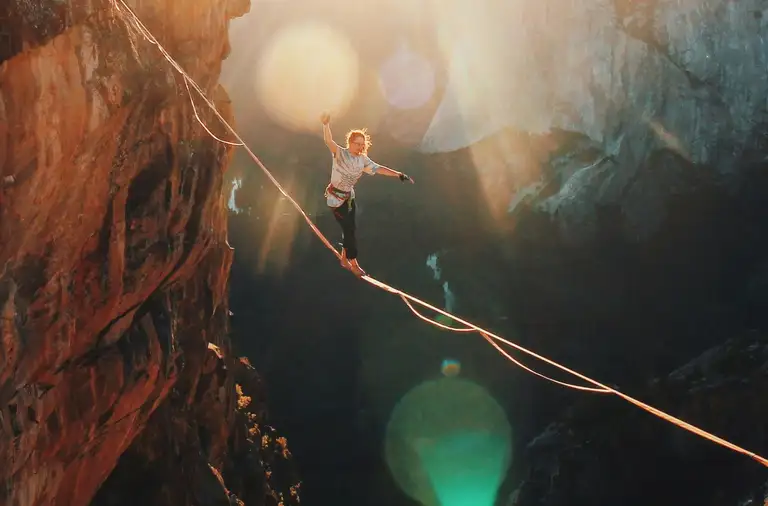 Man slacklining over canyon