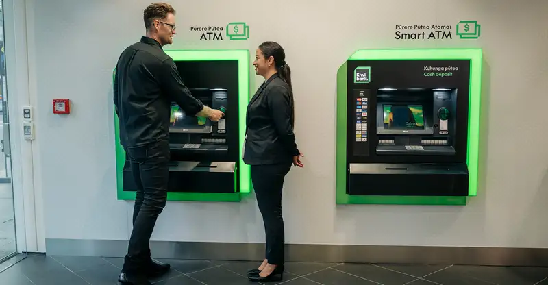 Staff at ATM with Customer Wide Shot