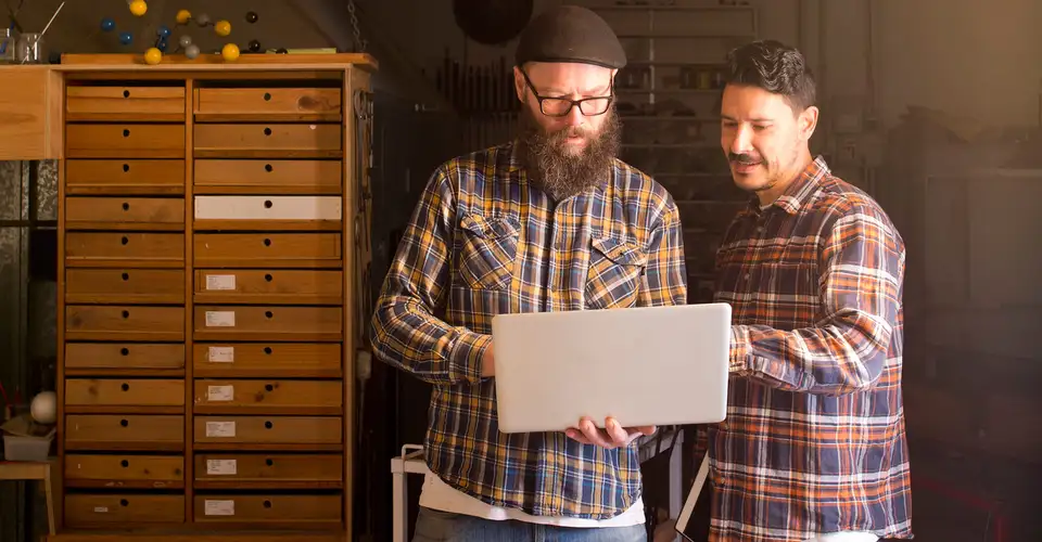 Two men with laptop in glass studio