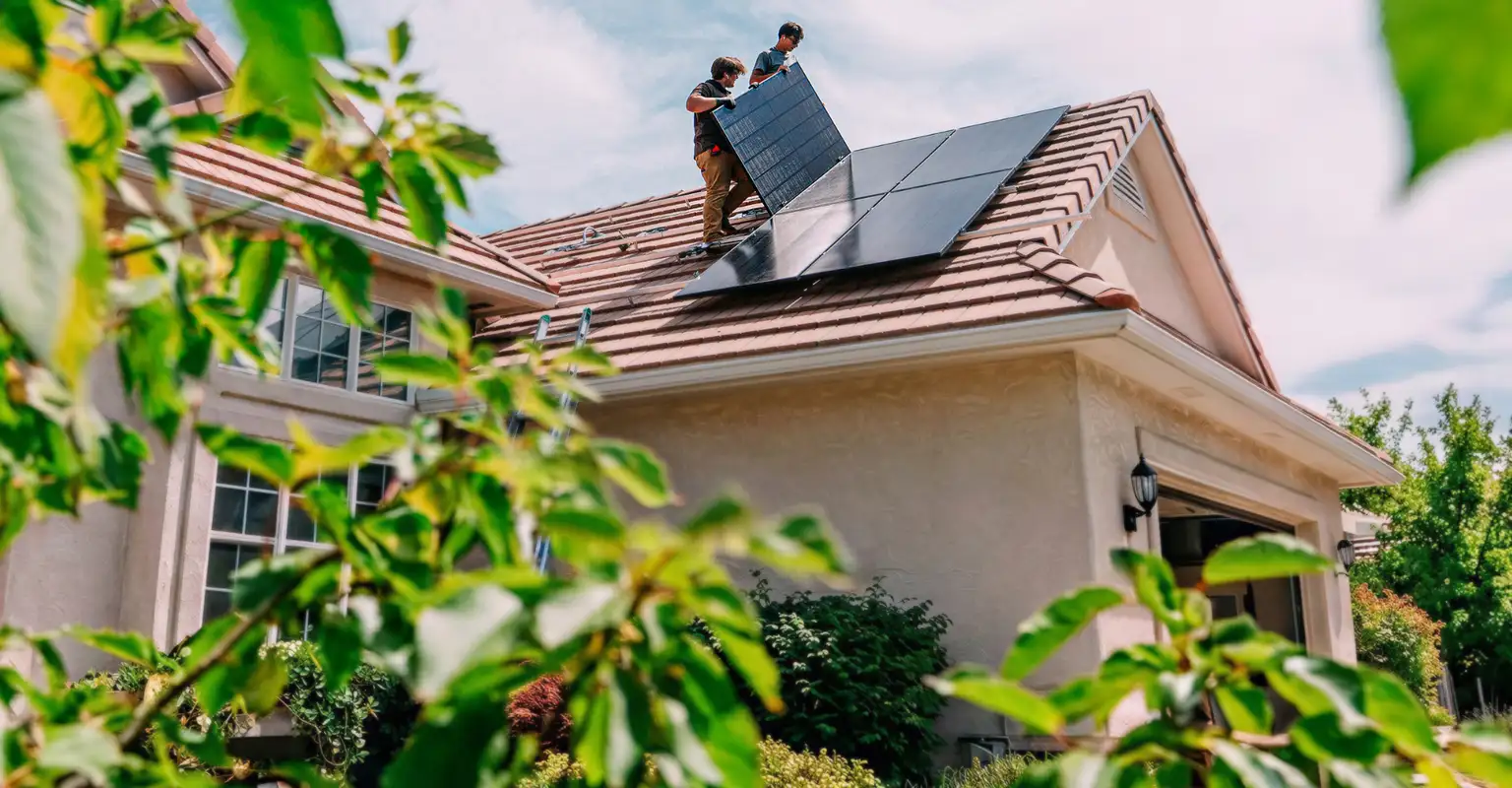 Two men putting solar panels on house roof  istock1756791456