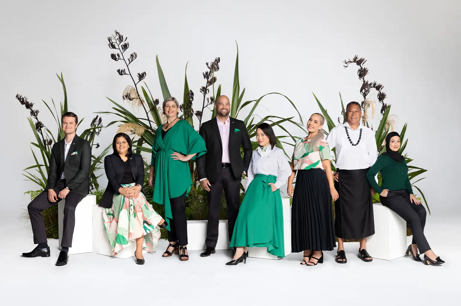 People standing and sitting among native plants in studio