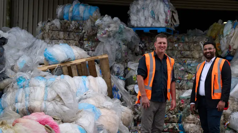 Men in hi-vis next to bundles of soft plastic